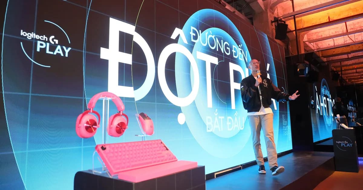 TK Nguyen speaking on stage at Logitech G PLAY 2026 in Ho Chi Minh City, a pink Logitech G headset, mouse and keyboard on display at the other end, the Logitech G PLAY logo and Đường đến Đột phá on the screen