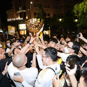 GAM fans reaching for the trophy during the GAM bus parade in Ho Chi Minh City