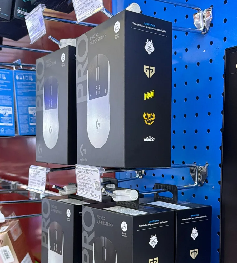 Logitech G PRO X2 SUPERSTRIKE boxes on a store shelf in Vietnam, the side panel showing the G2, Gen.G, NAVI and GAM crests and m0NESY's logo